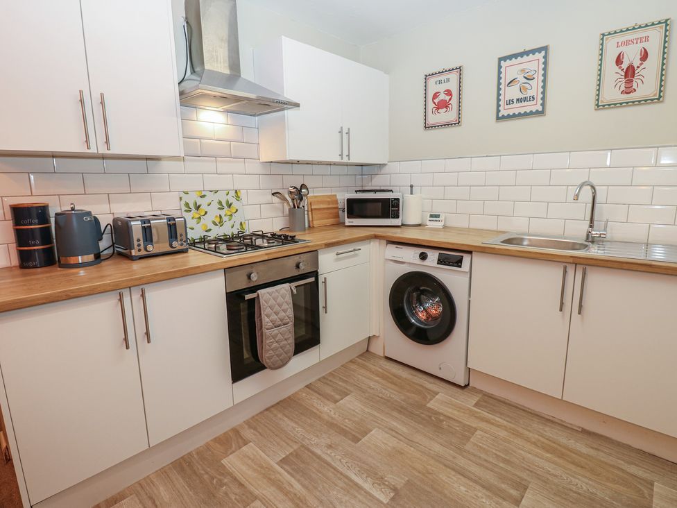 A kitchen with appliances and a washing machine at Eleven Tides in Seaham