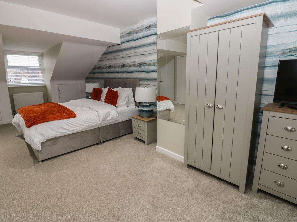 A bedroom with a bed and wardrobe at Eleven Tides in Seaham