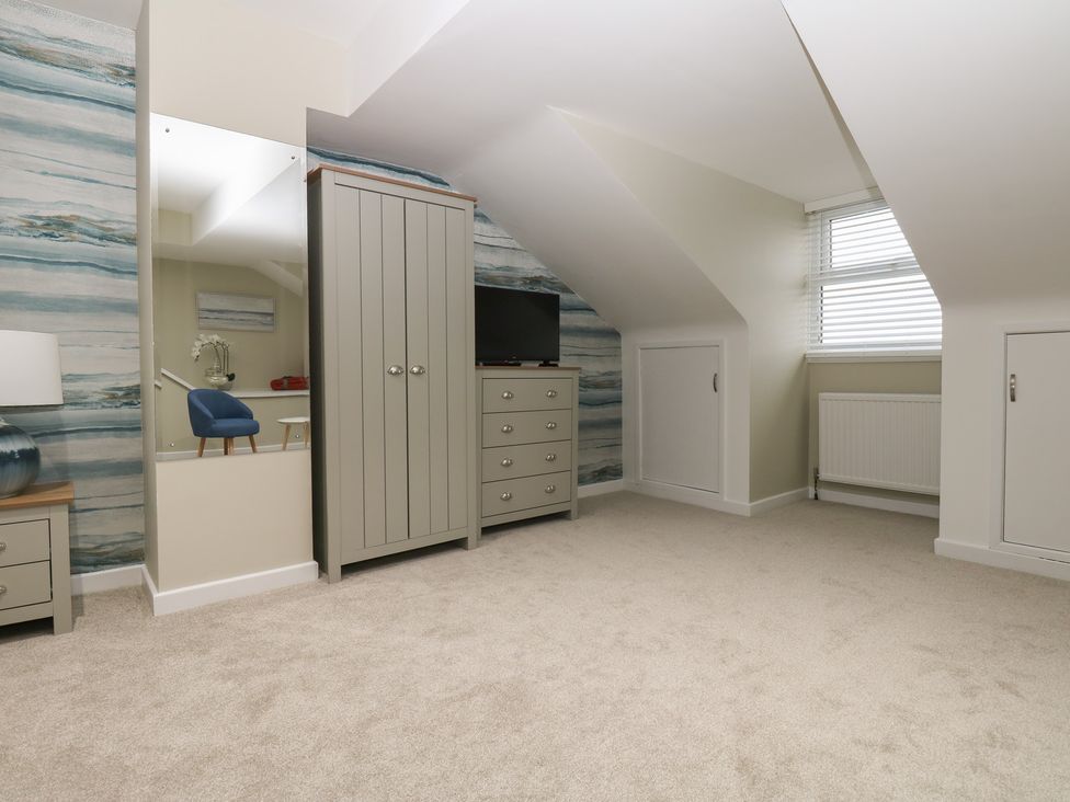A bedroom with a wardrobe and dresser at Eleven Tides in Seaham
