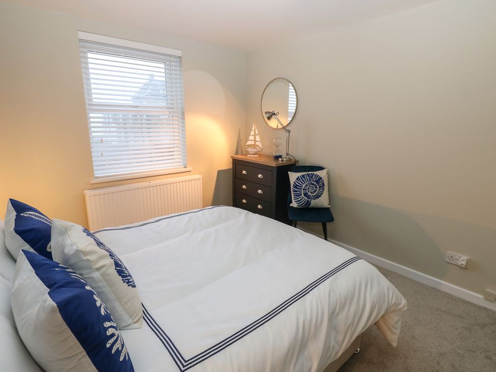 A bedroom with a bed and dresser at Eleven Tides in Seaham