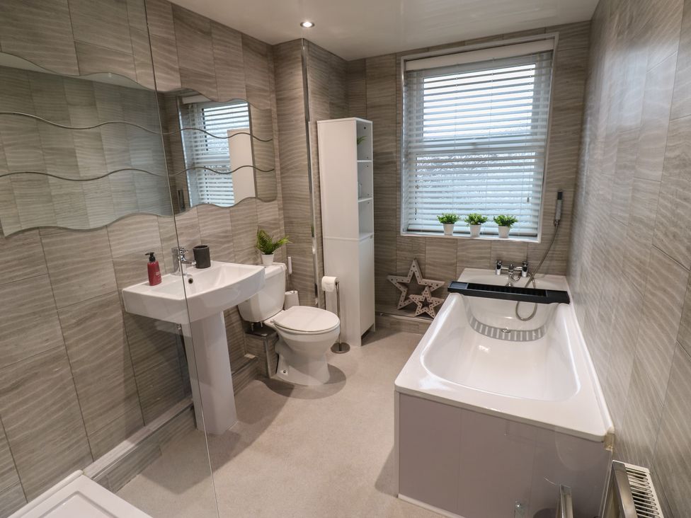 A bathroom featuring a sink, toilet, and bath at Eleven Tides in Seaham
