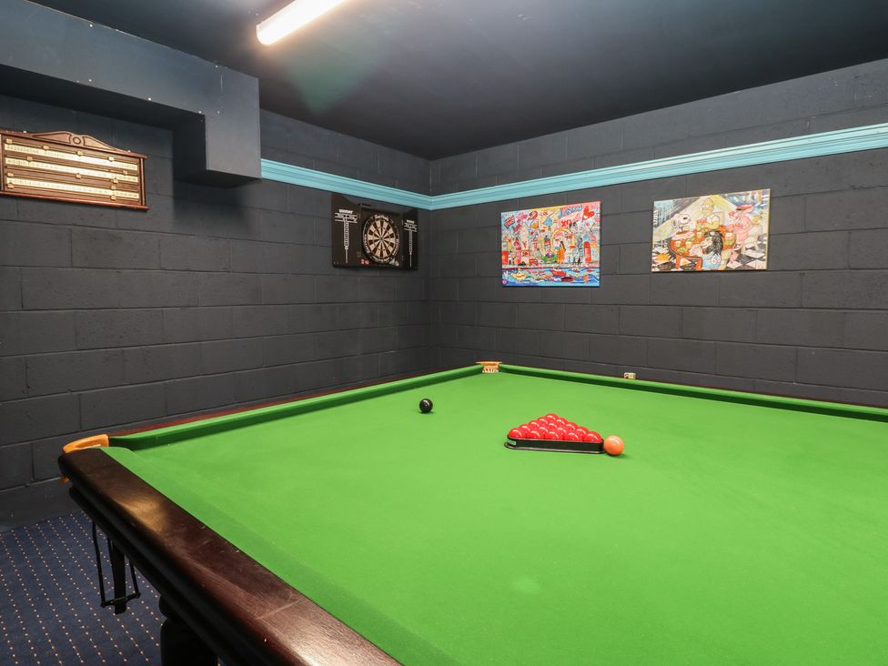 A game room with a pool table and dartboard at Eleven Tides in Seaham