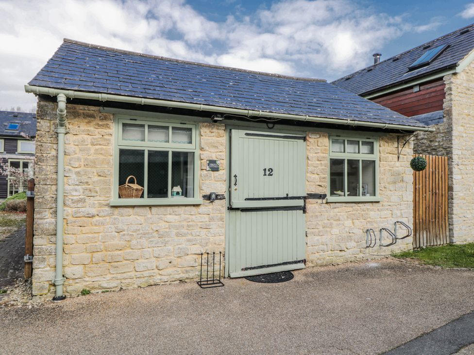 An exterior view of a cottage featuring a stone wall and slate roof at Firefly Cottage