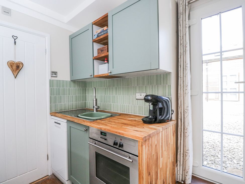 A kitchen with cabinets and a sink at Firefly Cottage 