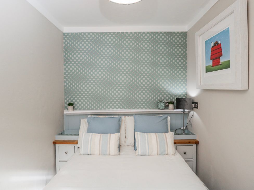 A bedroom with a bed and nightstand at Firefly Cottage