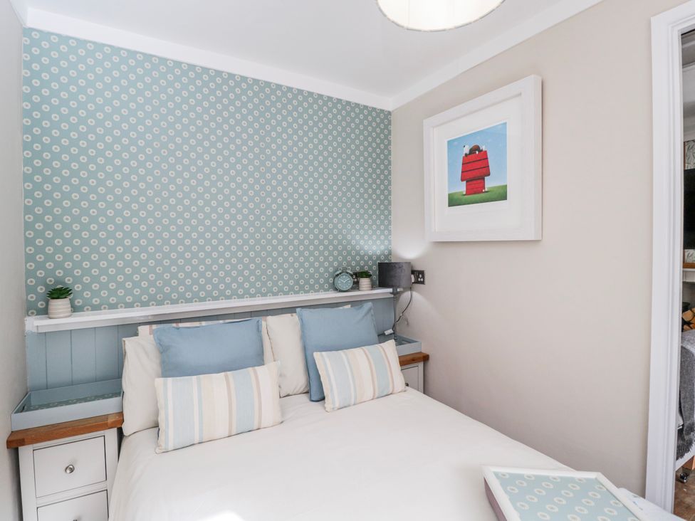 A bedroom with a bed and decorative wall at Firefly Cottage