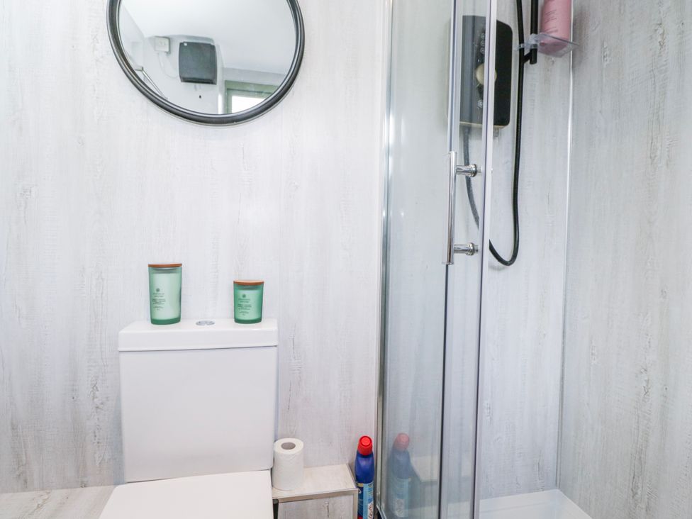 A bathroom with a toilet and shower at Firefly Cottage