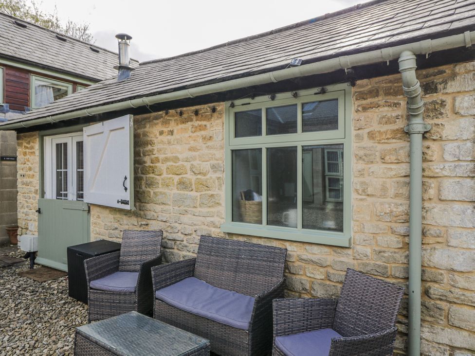 An outdoor seating area with chairs and a table at Firefly Cottage