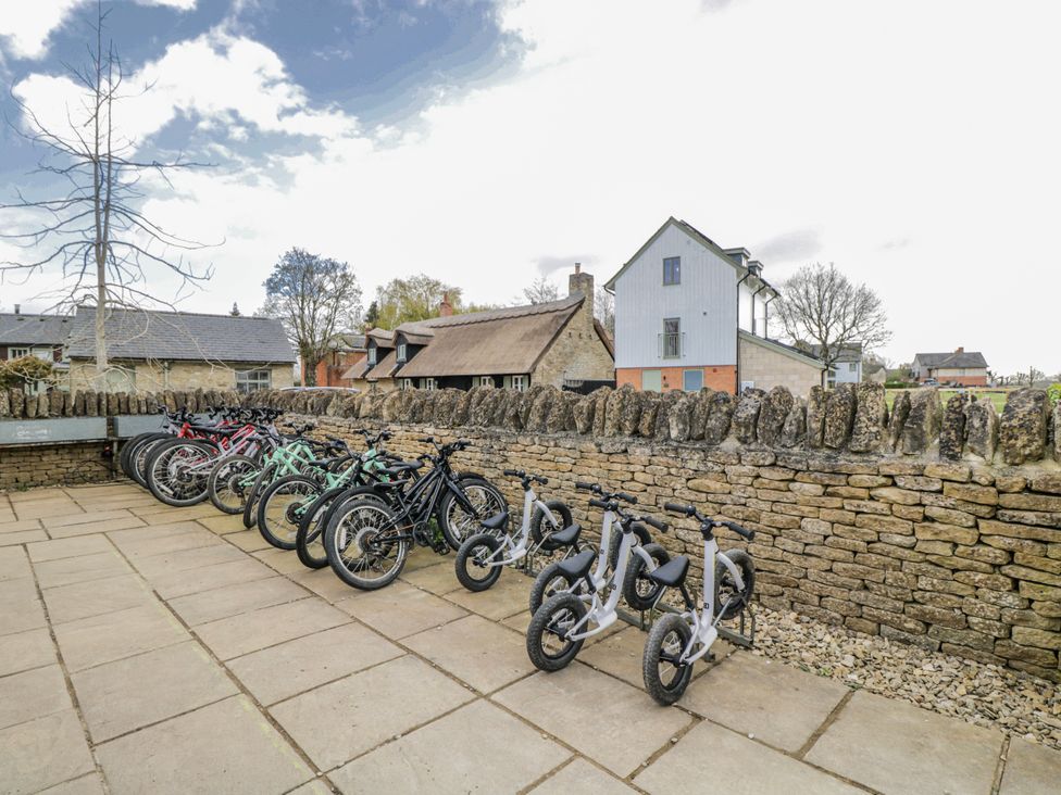 A row of bicycles and balance bikes near a stone wall at Firefly Cottage 