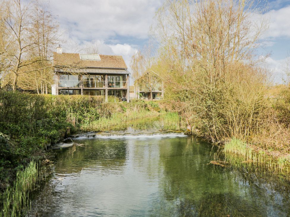 A view of a stream with buildings and trees at Firefly Cottage 