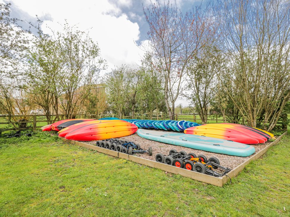 A collection of kayaks and paddle boards in an outdoor area at Firefly Cottage