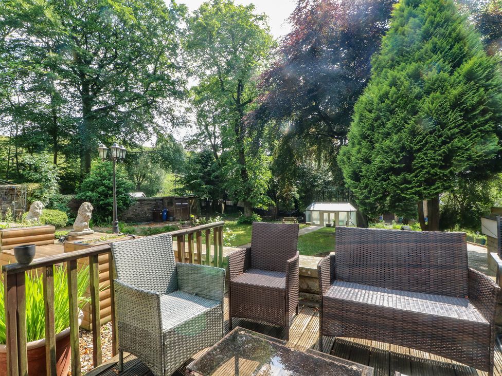Outdoor seating area with chairs and table in the garden at Stone House in Rossendale