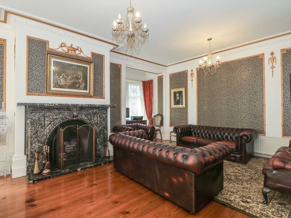 A living room with leather furniture and a fireplace at Stone House in Rossendale