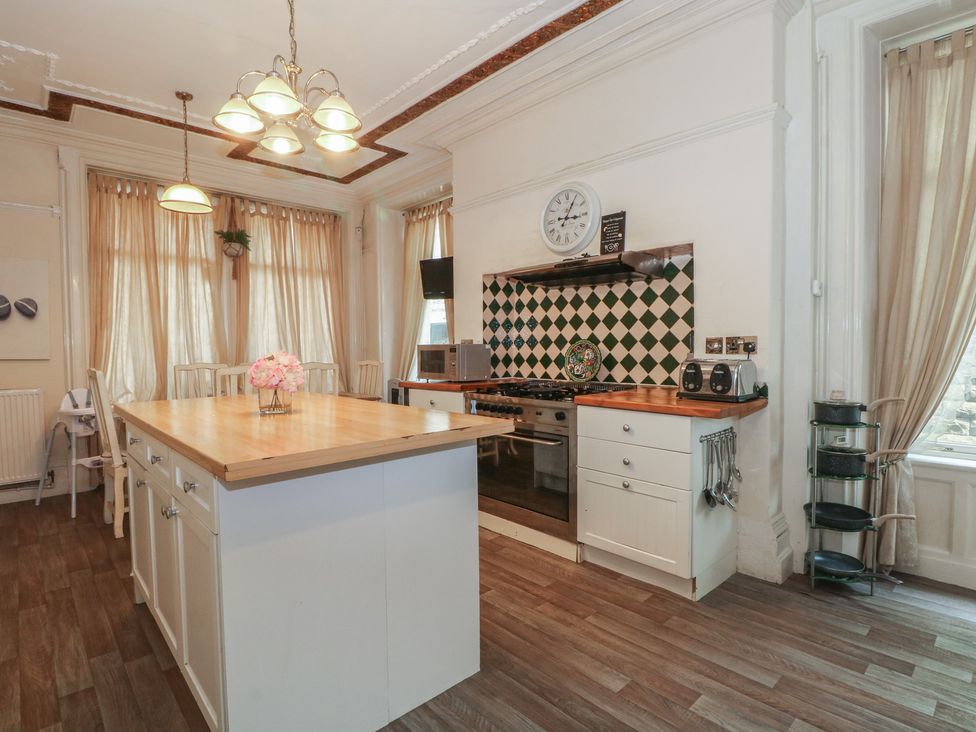 A kitchen with an island and appliances at Stone House in Rossendale