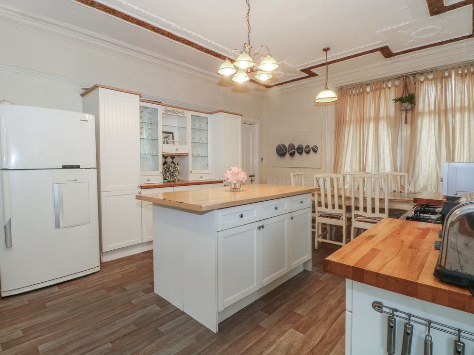 A kitchen with refrigerator and dining table at Stone House in Rossendale