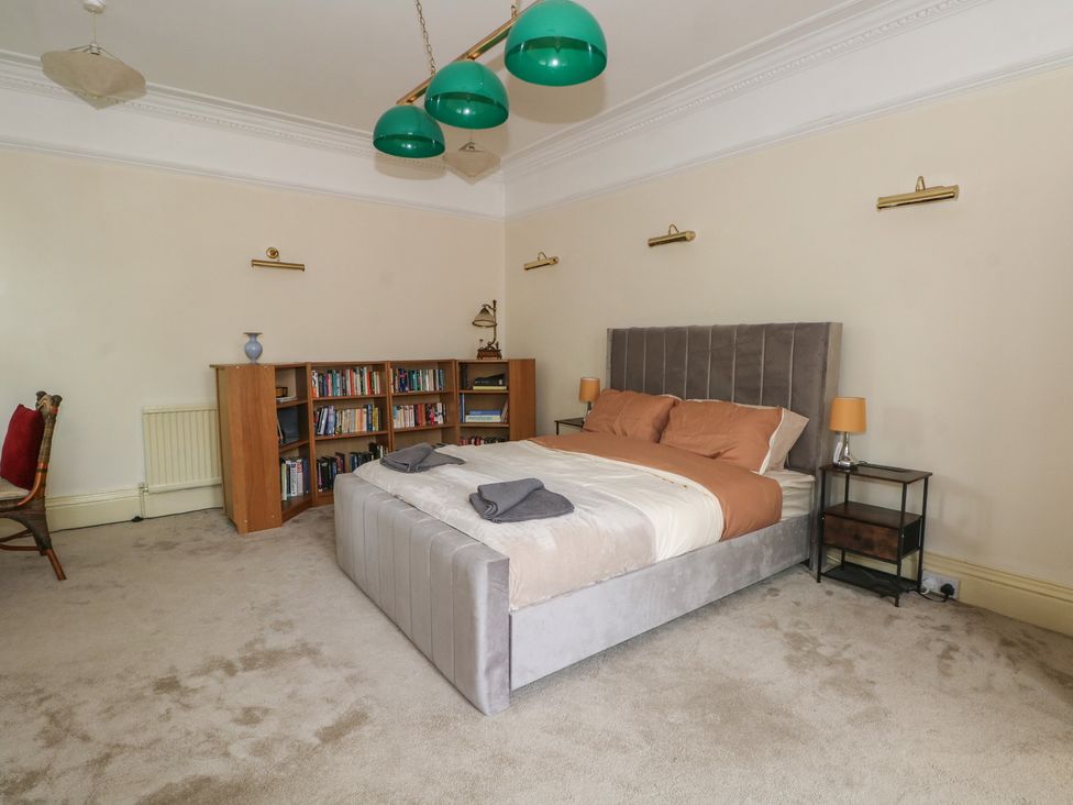 A bedroom with a bed and bookshelf at Stone House in Rossendale