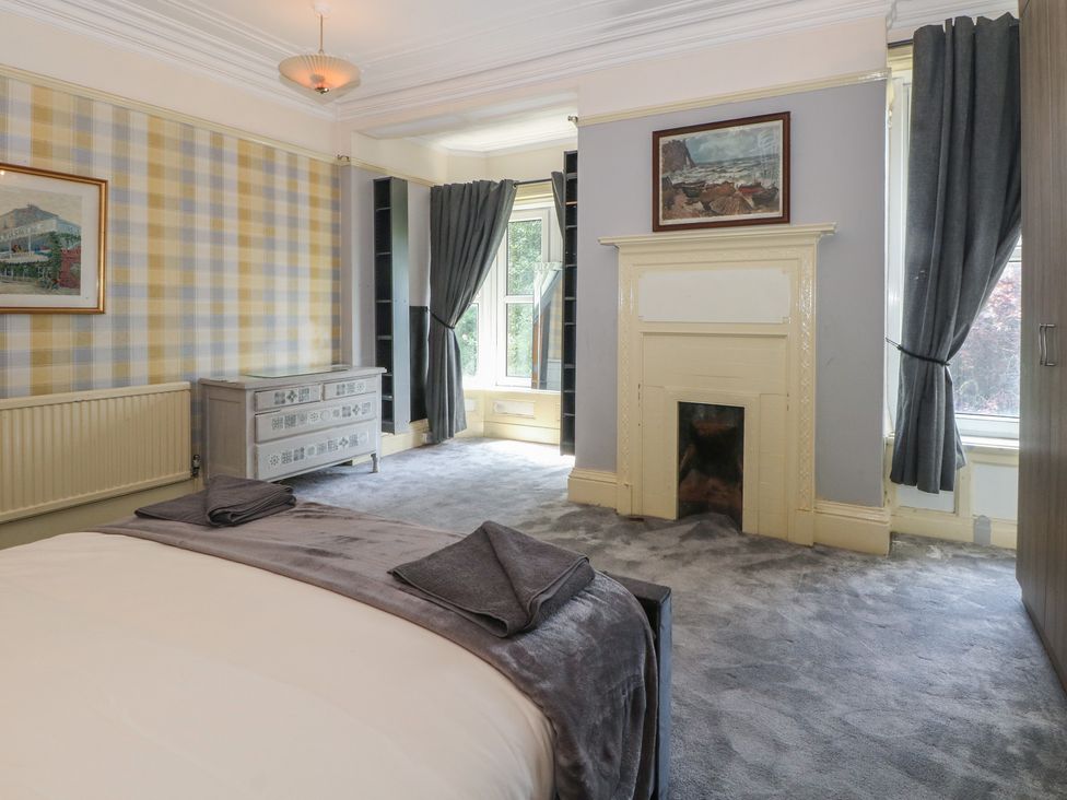A bedroom with a bed and a painting at Stone House in Rossendale