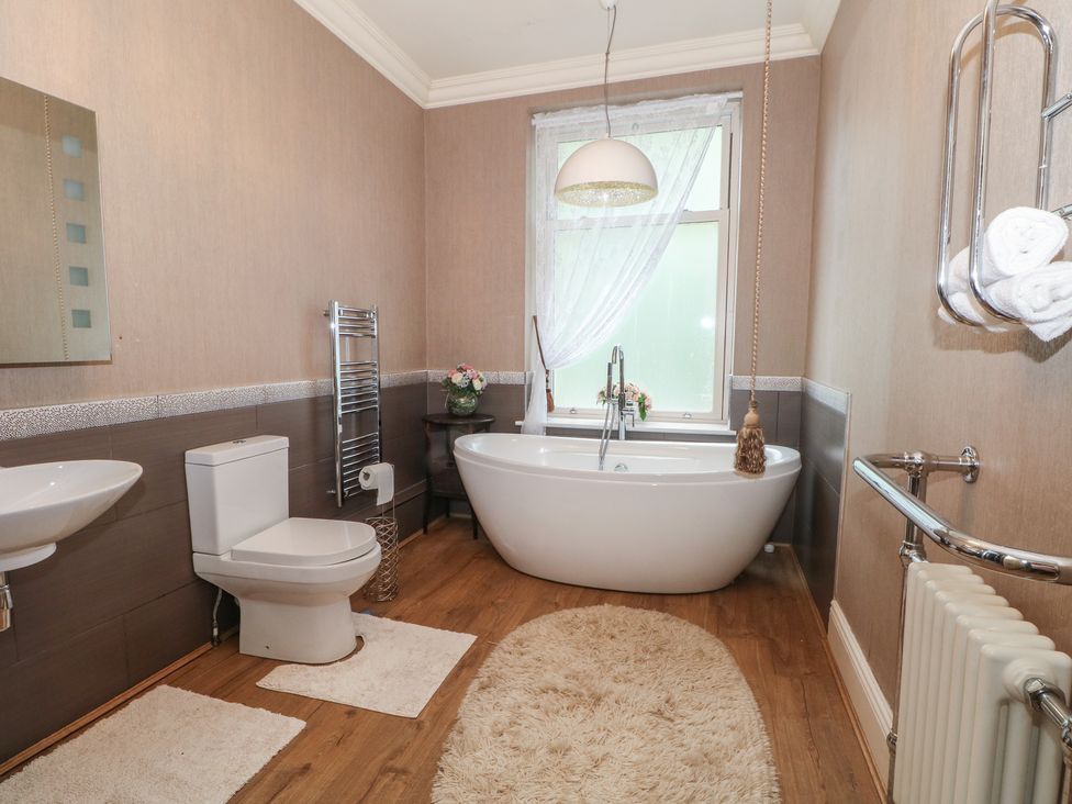 A bathroom with a bathtub and sink at Stone House in Rossendale