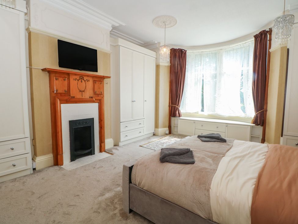 A bedroom with a bed and a fireplace at Stone House in Rossendale