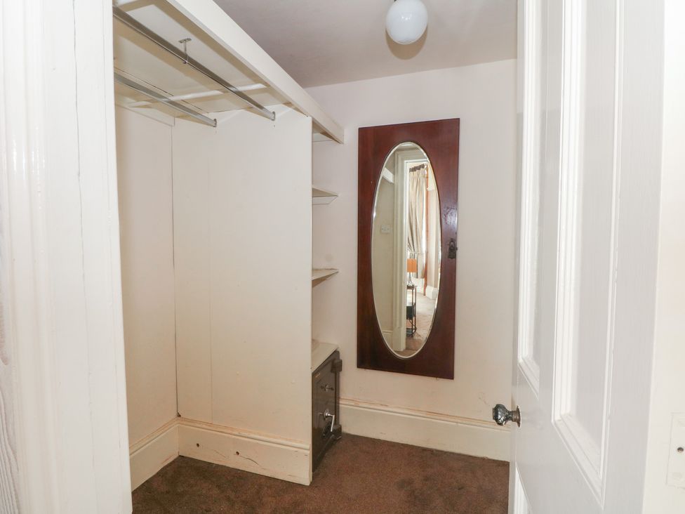 A closet with a mirror and shelves at Stone House in Rossendale