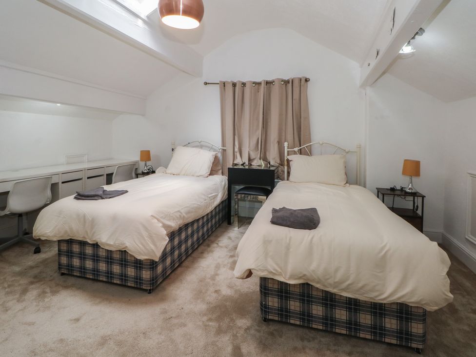 A bedroom with twin beds and a desk at Stone House in Rossendale