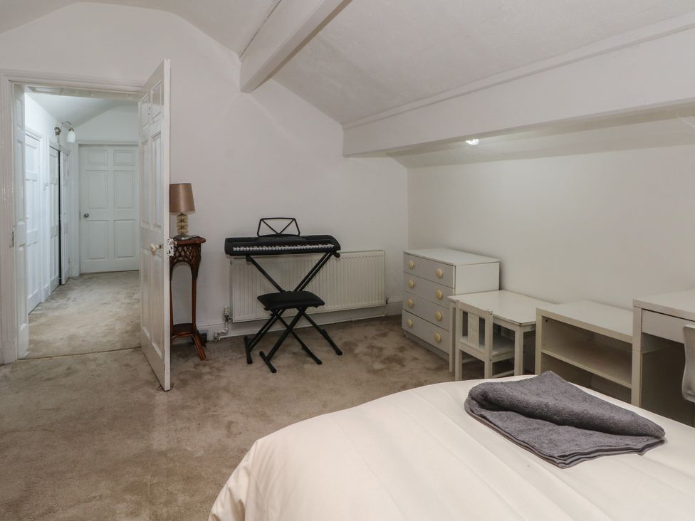 A bedroom with a piano keyboard and a desk at Stone House in Rossendale