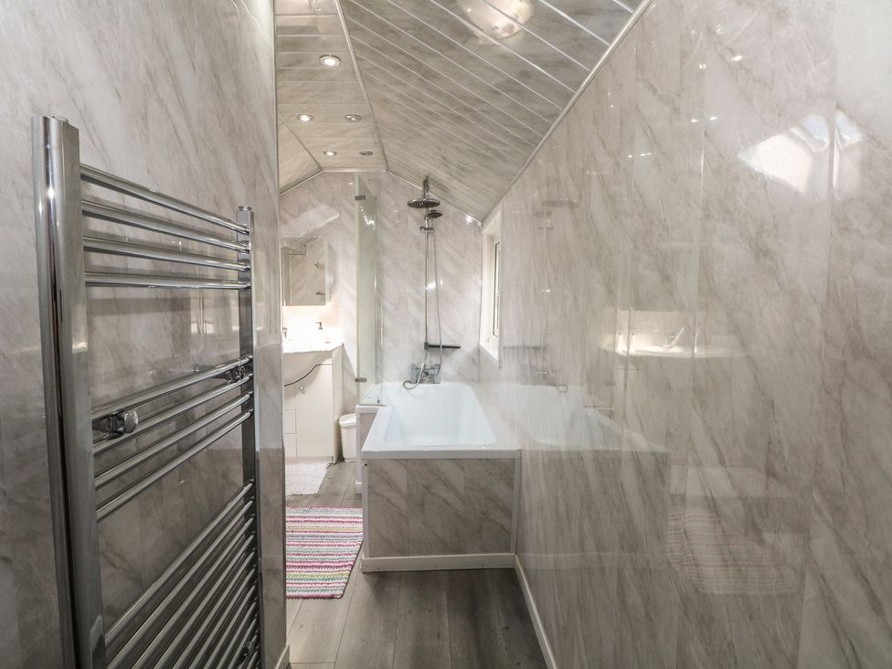 A bathroom with a bath tub and shower at Stone House Rossendale