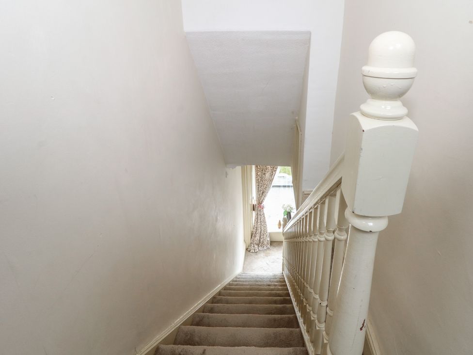 A staircase with a banister and curtain at Stone House in Rossendale