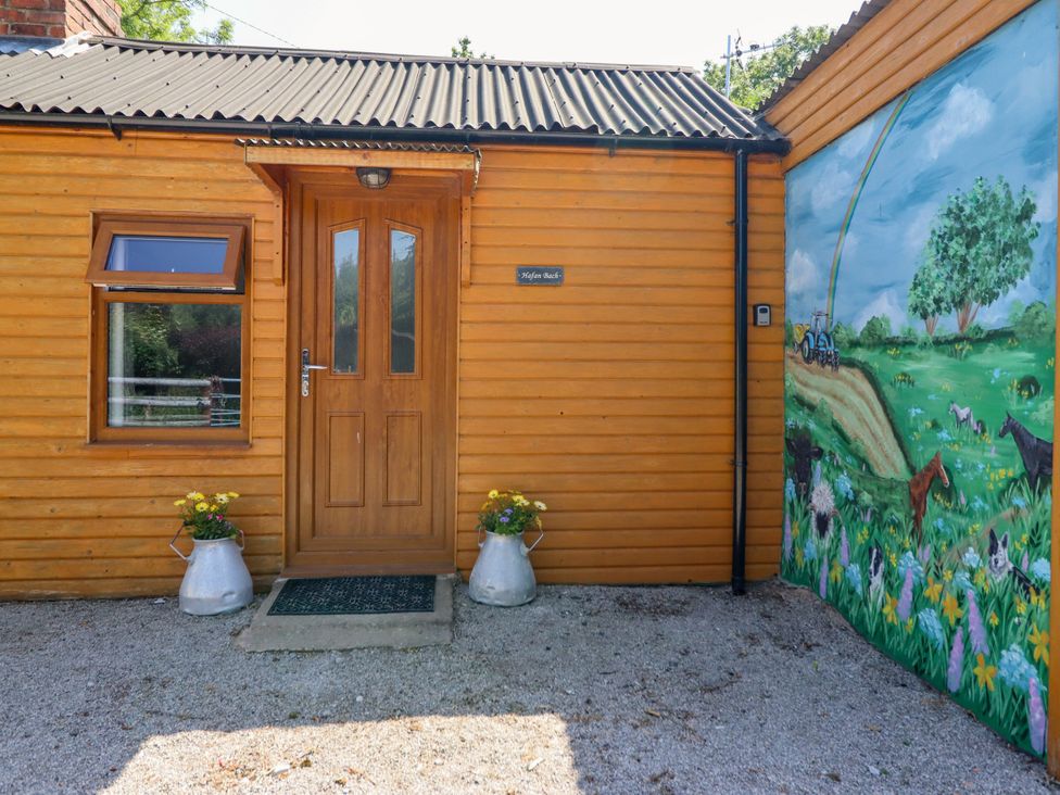 An entrance area with flower pots and a mural at Haven in Lloc near Holywell