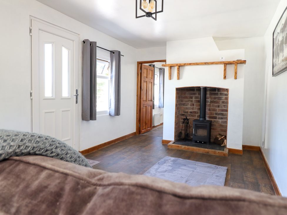 A living room with a fireplace and door at Haven in Lloc near Holywell