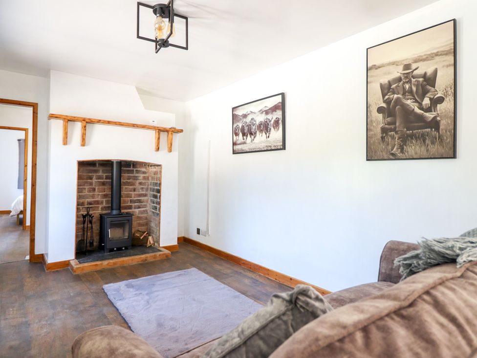 A living room with a fireplace and photographs at Haven Lloc near Holywell