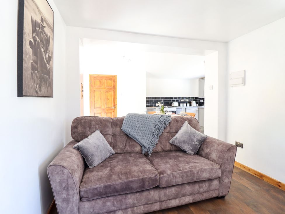 A living room with a sofa and painting at Haven in Lloc near Holywell