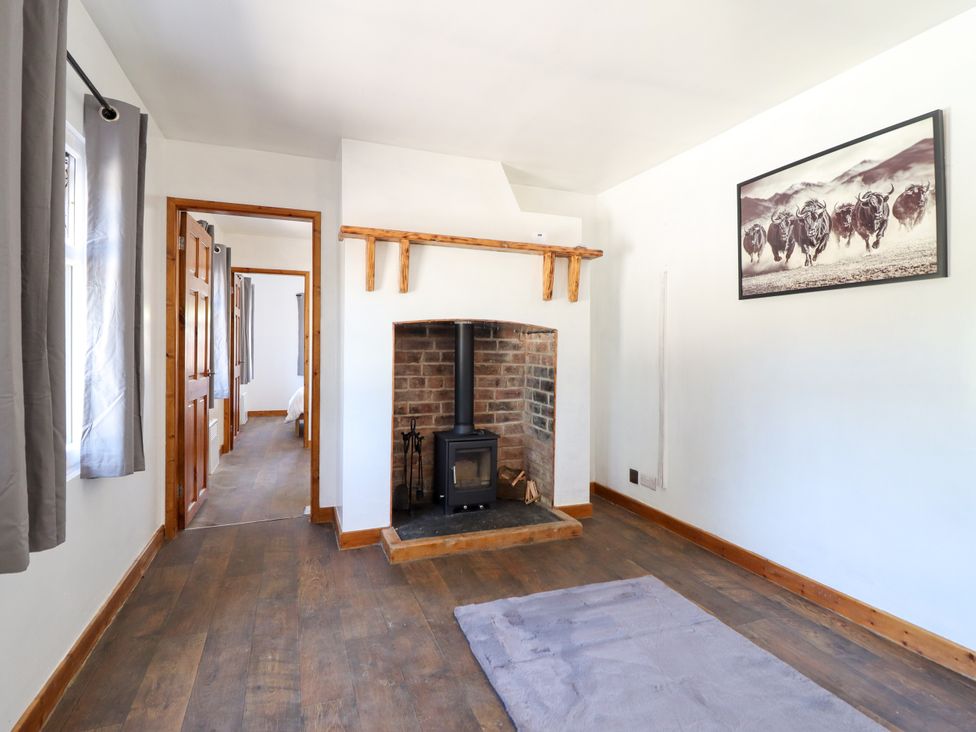 A living room with a fireplace and stove at Haven in Lloc near Holywell