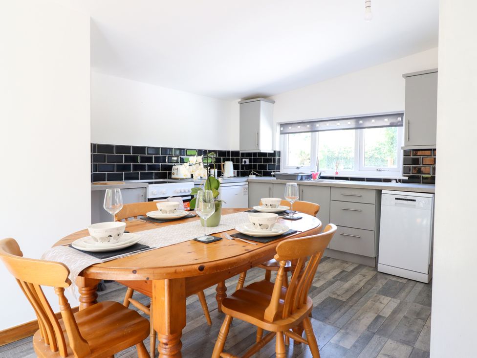 A kitchen with a dining table and chairs at Haven in Lloc near Holywell