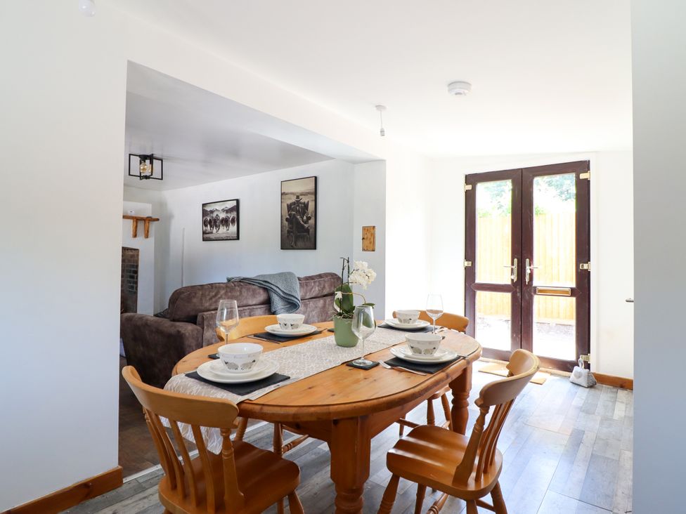 A dining room with a wooden table and chairs at Haven in Lloc near Holywell