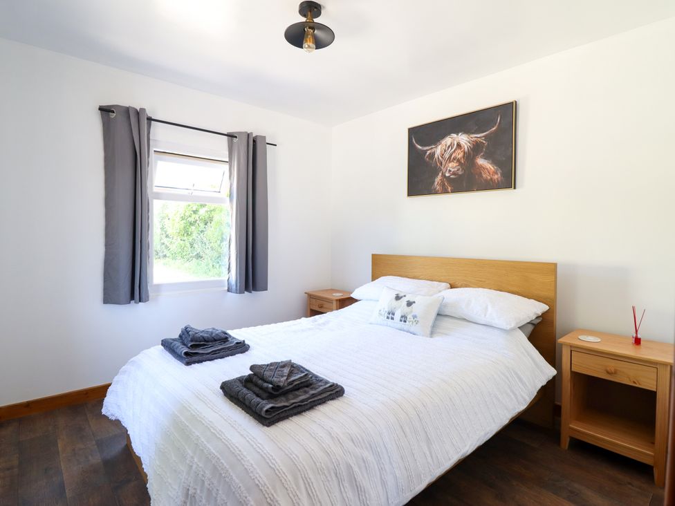A bedroom with a bed and nightstand at Haven in Lloc near Holywell