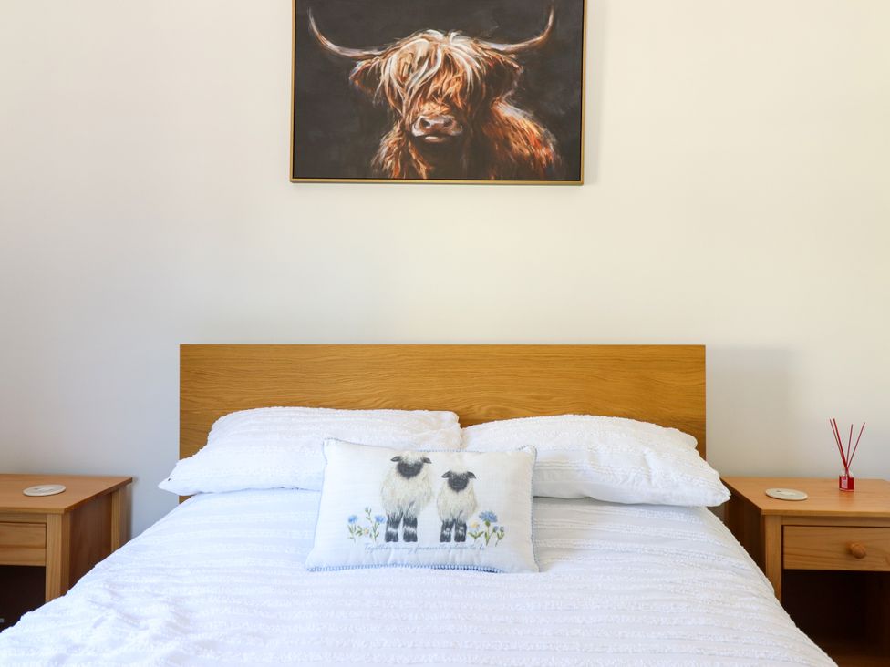 A bedroom with a bed and artwork on the wall at Haven in Lloc near Holywell