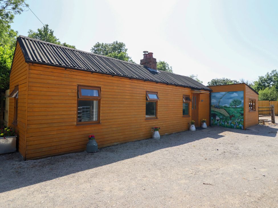 An exterior view of a wooden house with a mural at Haven in Lloc near Holywell