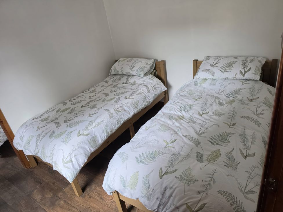 A bedroom with two beds and bedding at Hafan Bach in Lloc near Holywell