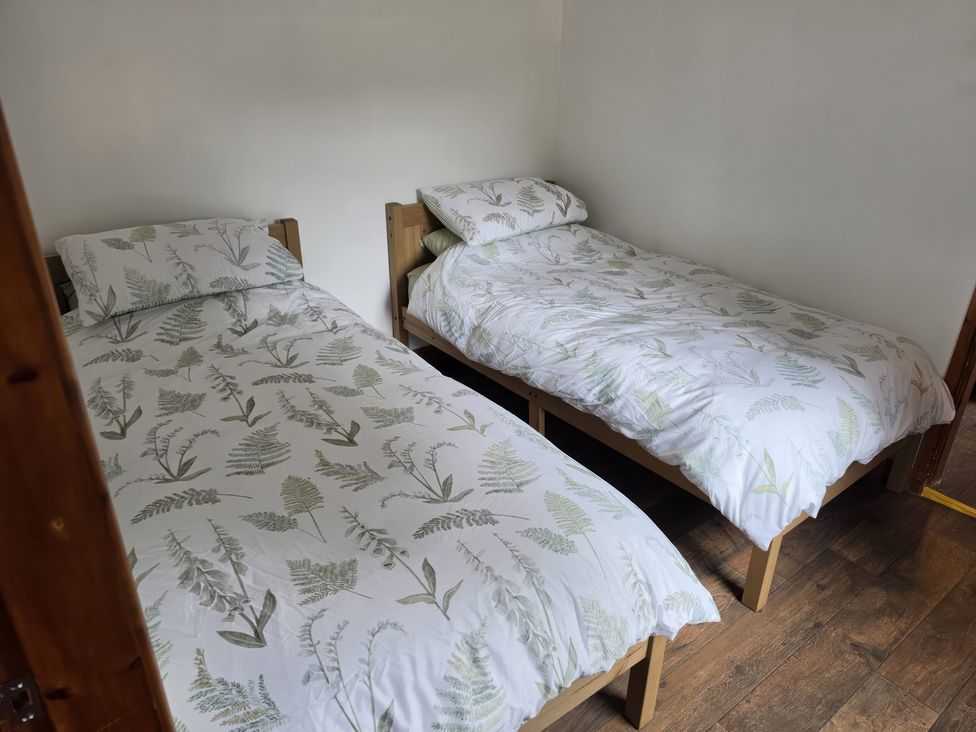 A bedroom with two beds and bedding at Hafan Bach in Lloc near Holywell