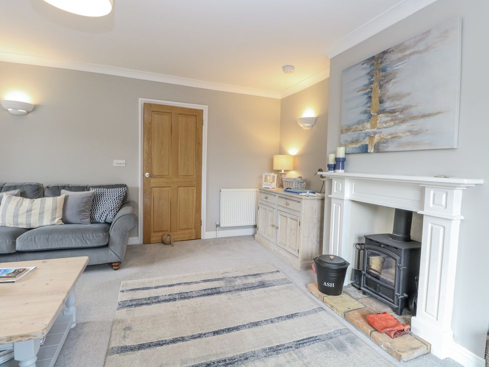 A living room with a sofa and fireplace at Woodlark