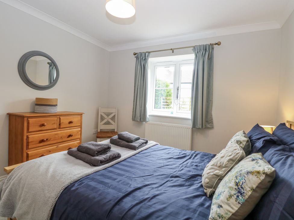 A bedroom with a bed and dresser at Woodlark
