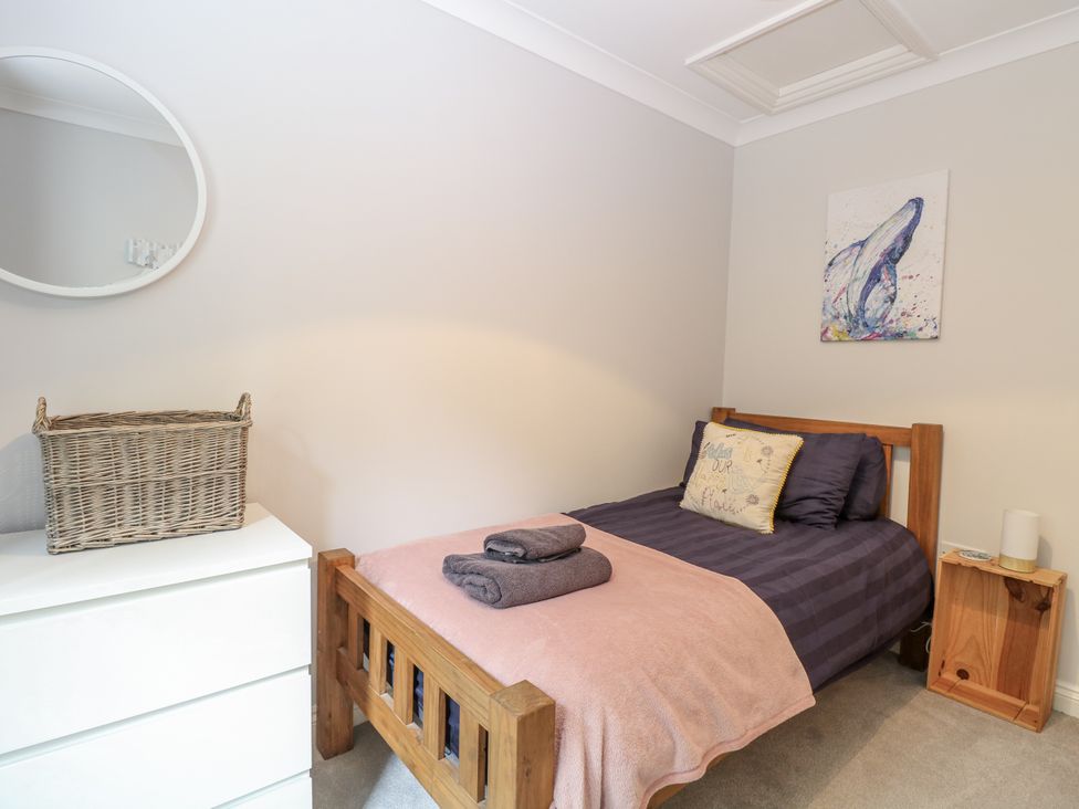 A bedroom with a bed and a mirror at Woodlark 