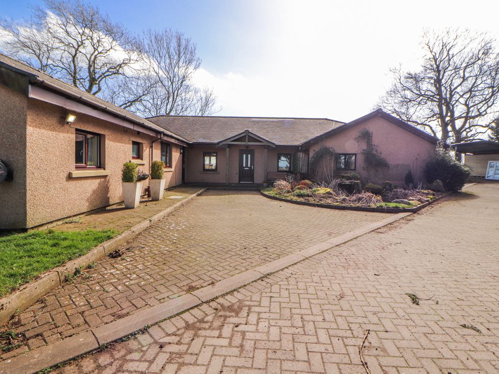 An outdoor view of a building with a driveway and garden at Old Riggs Paddock Penrith