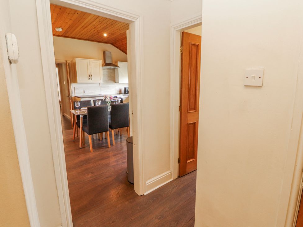 A hallway leading to a kitchen with a dining table and chairs at Old Riggs Paddock in Penrith