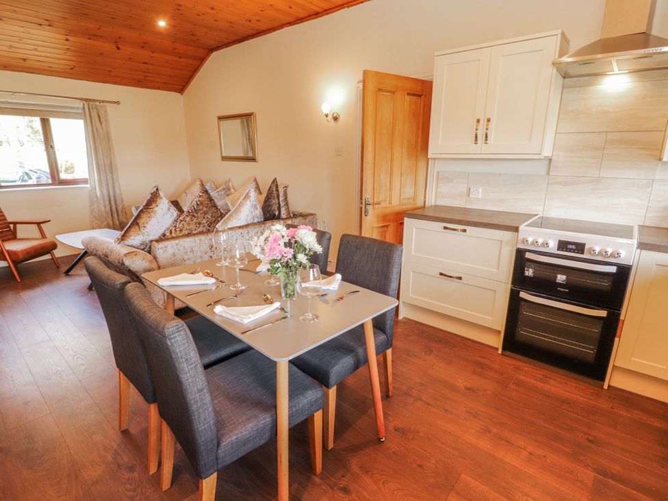 A living room with a dining area and kitchen appliances at Old Riggs Paddock in Penrith