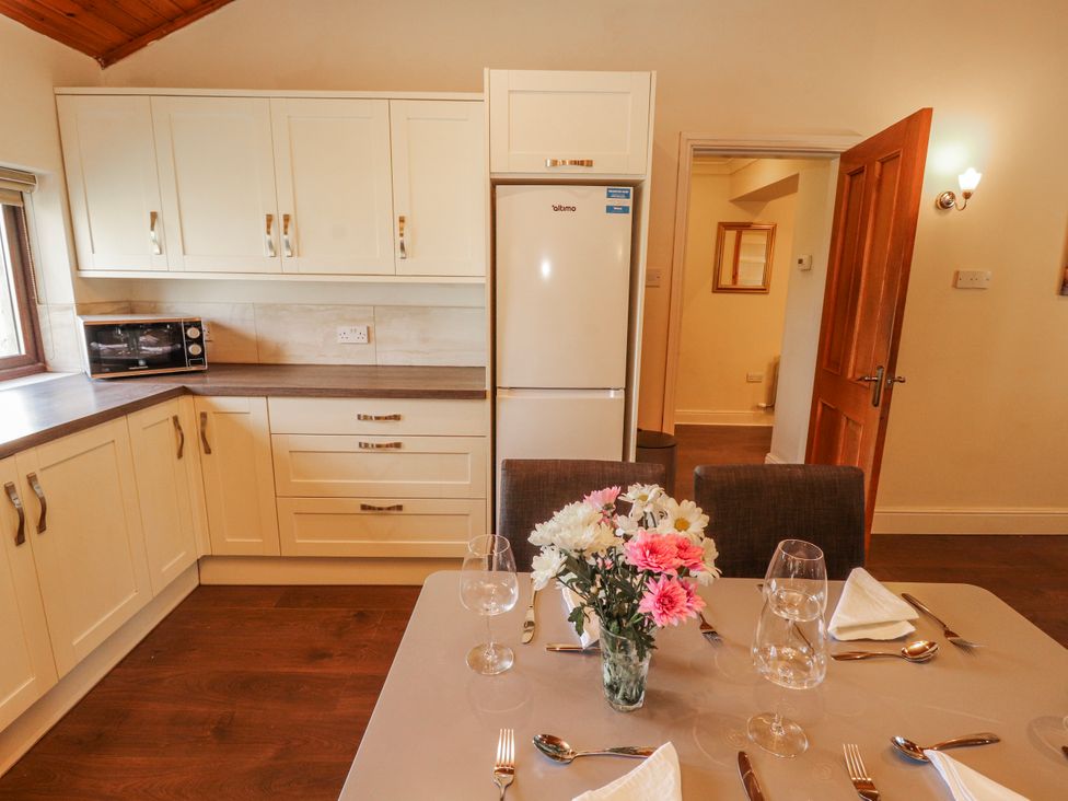 A kitchen with a dining table and refrigerator at Old Riggs Paddock in Penrith