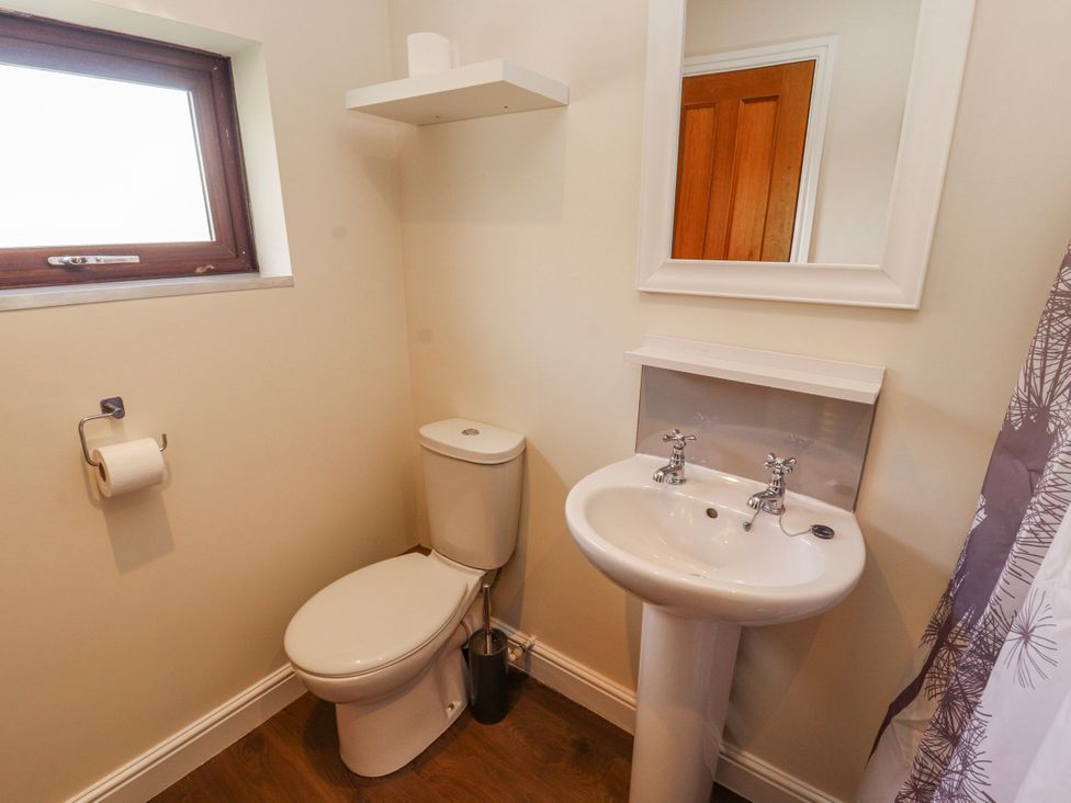 A bathroom with a sink, toilet, and mirror at Old Riggs Paddock in Penrith