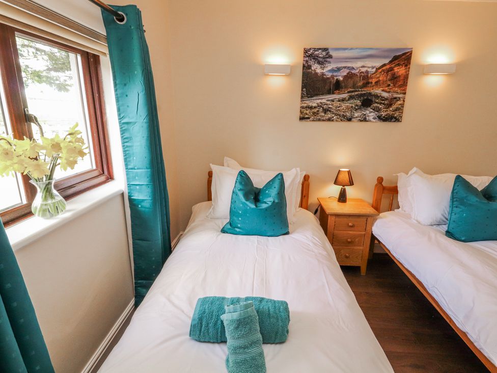 A bedroom with twin beds and a nightstand at Old Riggs Paddock in Penrith