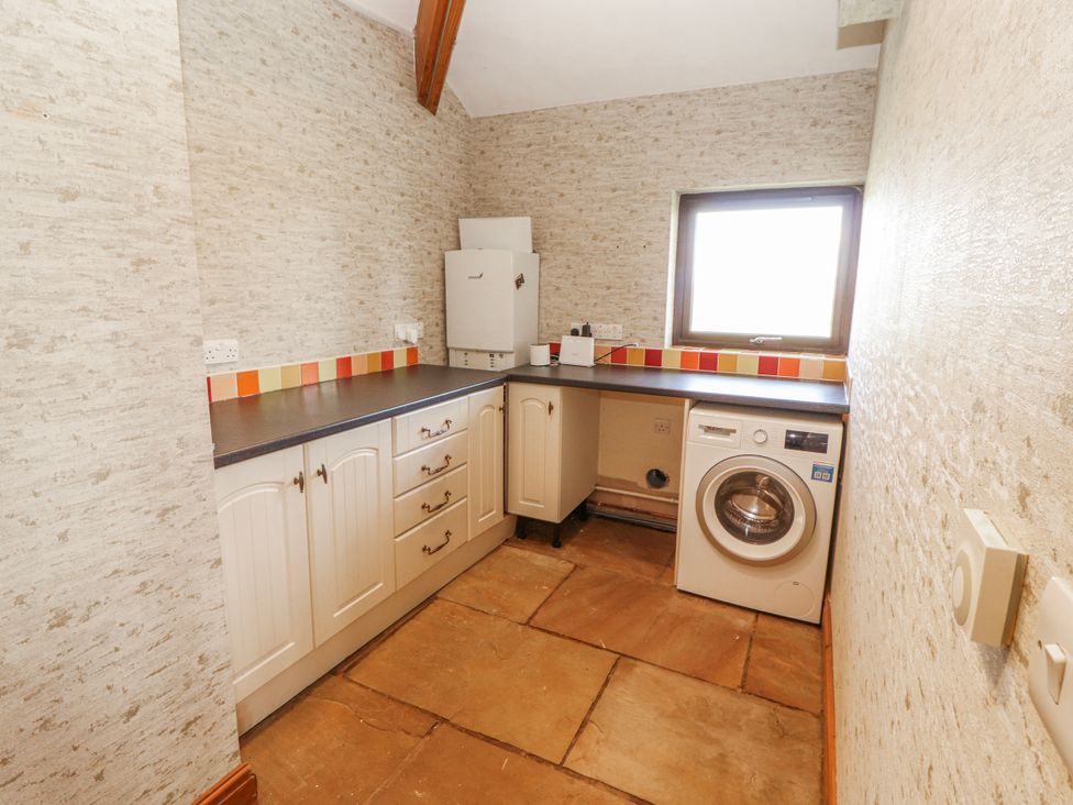 A laundry room with a washing machine and countertop at Old Riggs Paddock in Penrith